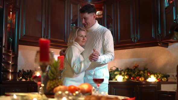 Loving Romantic Husband and Wife Dancing in Kitchen at Home Indoors