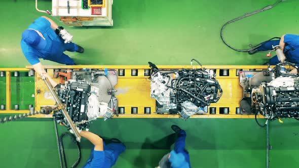 Car Factory Workers Assembling Car Engines