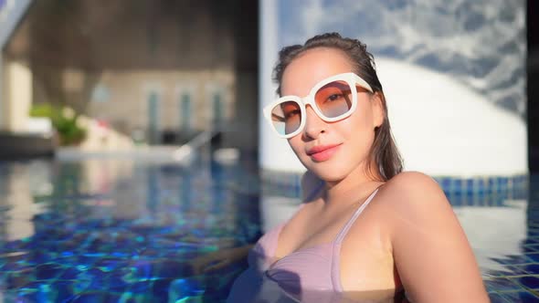 Young asian woman enjoy around outdoor swimming pool for leisure