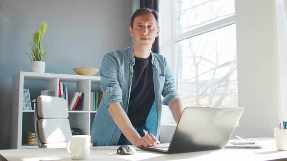 Young male entrepreneur works at home office at the computer.