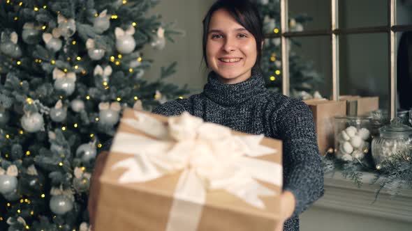 Portrait of Smiling Girl Holding Gift Box Then Stretching Her Hands Offering Present Congratulating