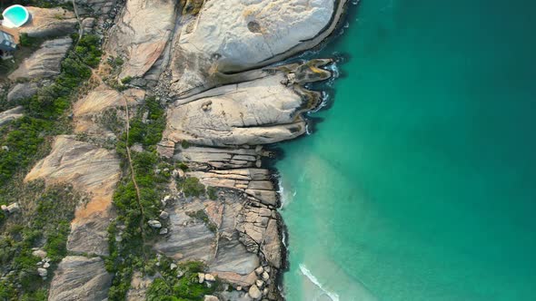 top down view of large boulders on turquoise blue ocean at Llandudno Beach, aerial
