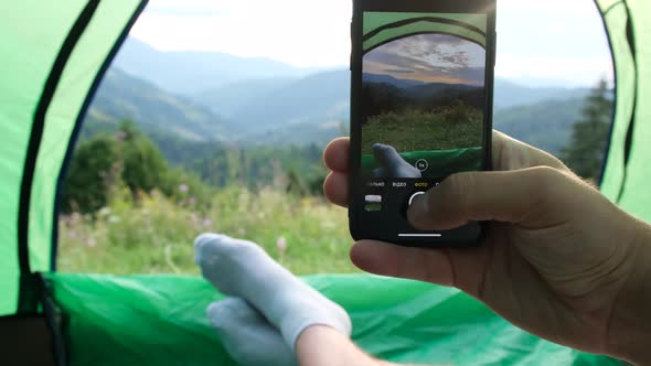 A Man Takes a Photo on a Smartphone From a Tent in the Mountains of the Ukrainian Carpathians