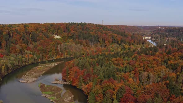 Short autumn expression clip of a curvy river framed by fall colorful trees filmed from above.