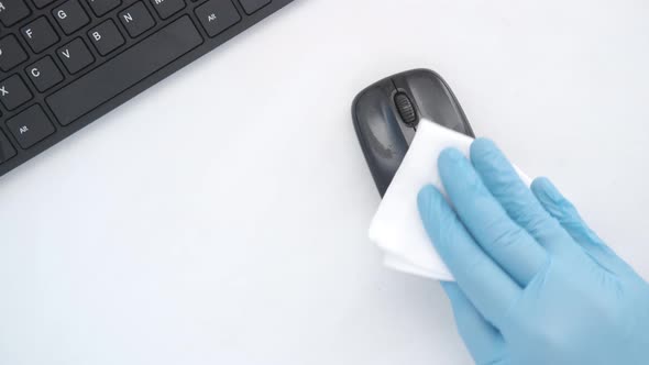 Hand in Blue Rubber Gloves and White Tissue Disinfecting Computer Mouse