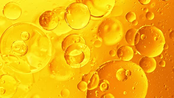 Super Slow Motion Shot of Moving Oil Bubbles on Golden Background at 1000Fps