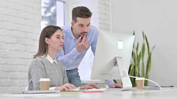 Creative Team Discussing Doing Paperwork on Desktop in Modern Office