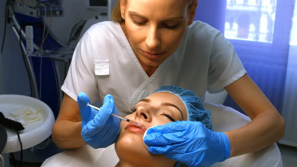 Doctor inserting facial injection on female patient lips