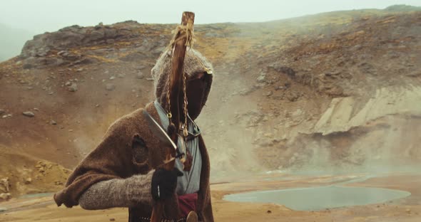 Mysterious Man In Hood Walking In Desert Landscape