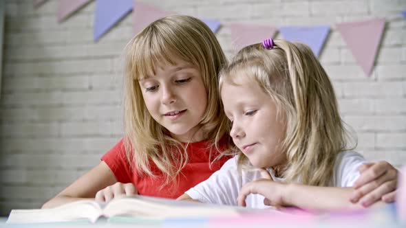 Blond Sisters Reading Book Together