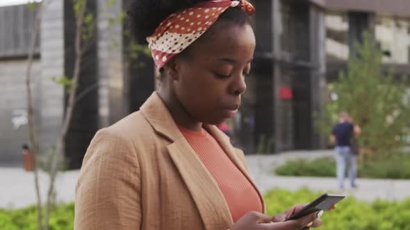  Black Woman Walking to Work and Typing on Phone