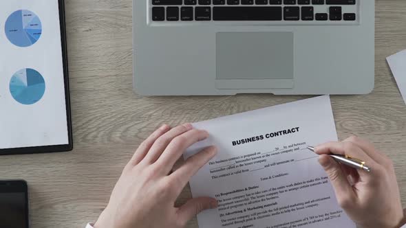 Man Reading Business Contract, Spinning Pen and Thinking About Its Conditions