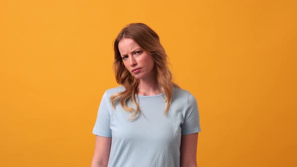 Displeased blonde woman wearing blue t-shirt giving negative answer