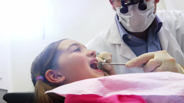 Dentist examining a young patient with dental tools