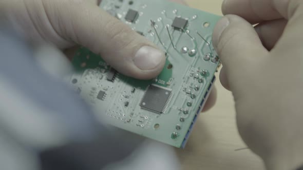 A Worker Is Working on the Production of an Electronic Board. Close-up.