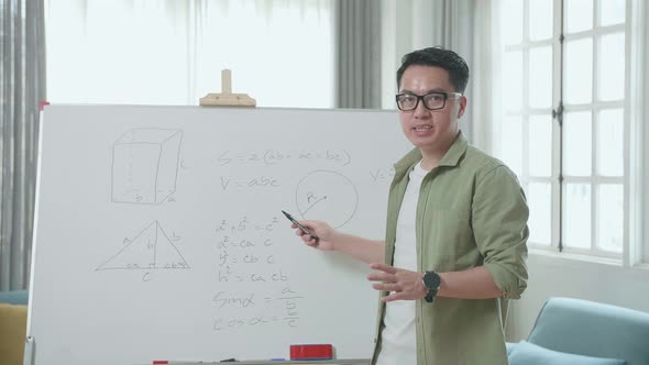 Asian Male Teacher With Glasses Teaching Math At Home