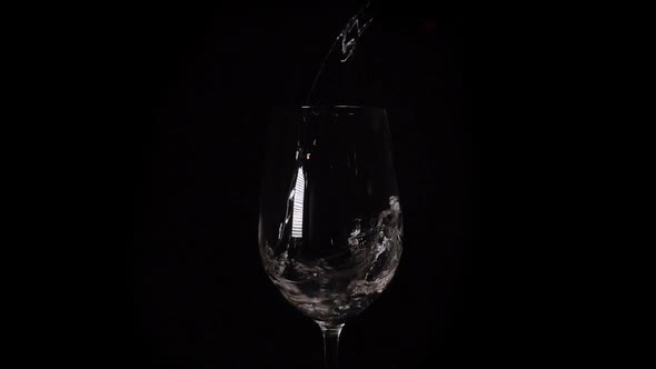Filling a Glass with Fresh Mineral Water on Black Background. Healthy Drinking. Slow Motion Footage