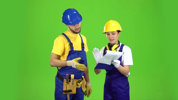 Designer Girl Shows a Sketch of a Building To a Builder. Green Screen