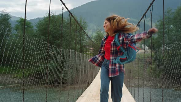 Happy Traveler Jumping Mountains on River Bridge