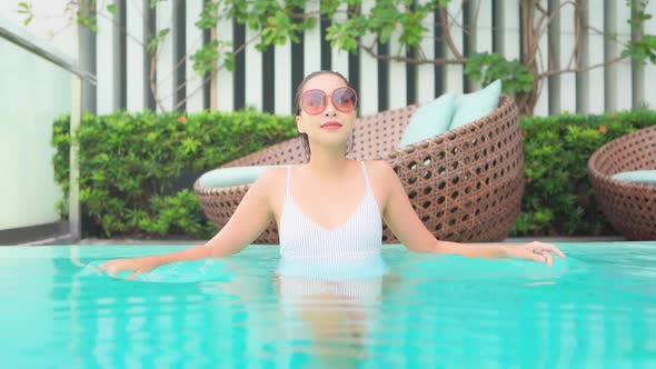 Young asian woman enjoy around outdoor swimming pool for leisure