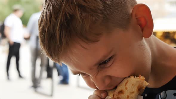 a Hungry Teenager Greedily Bites Off Shawarma and Chews with Pleasure