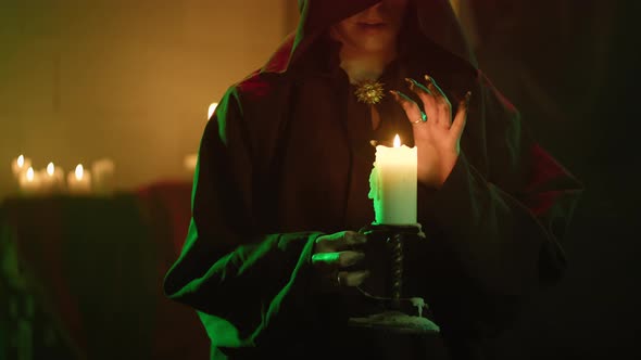 Witch Woman Blowing Out Candle Closeup