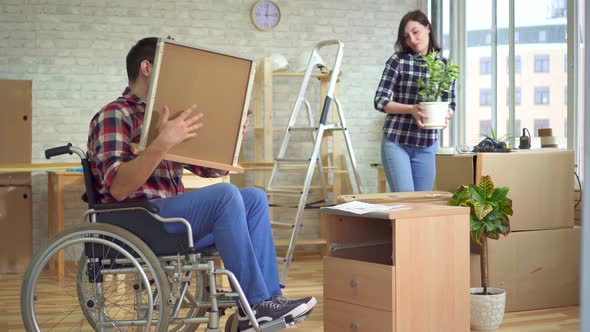 Concept of Moving a Disabled Man in a Wheelchair Collects a Bedside Table Next To His Wife