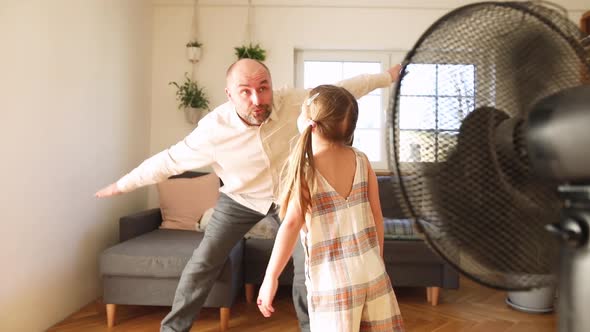 Father playing with his daughter pretending to fly at home