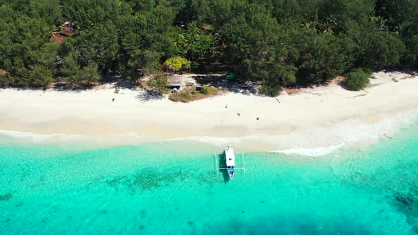 Traditional Asian boat anchoring on shore calm transparent water of azure lagoon washing white exoti