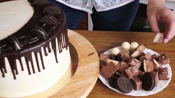 Woman's hands decorating a drip cake