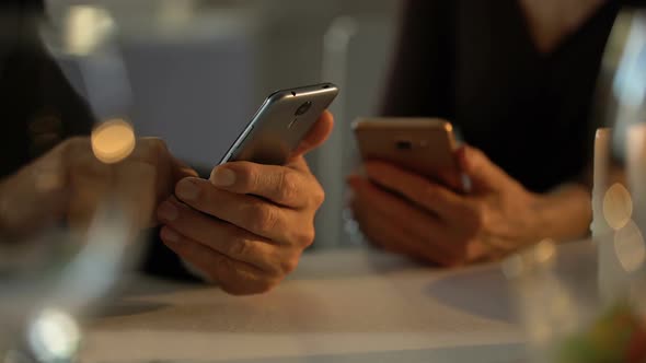 Adult Couple Scrolling Smartphones Instead Romantic Date in Restaurant, Ignore