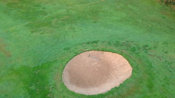 Aerial rising shot of golf course at sunset.