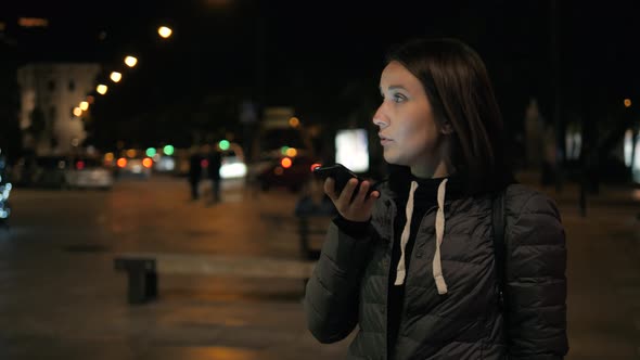 Woman Tourist Voice Recognition Ai Sending Audio Message on Cellphone Phone at Night City Street