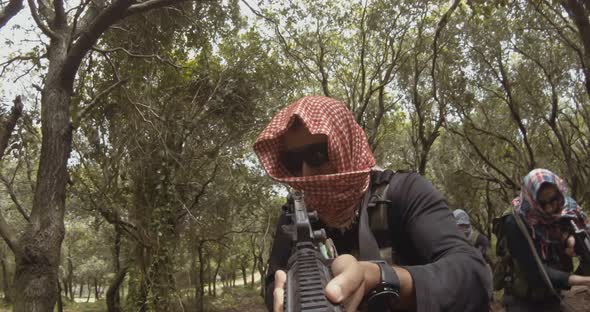 POV footage of armed terrorists patrolling a forest area