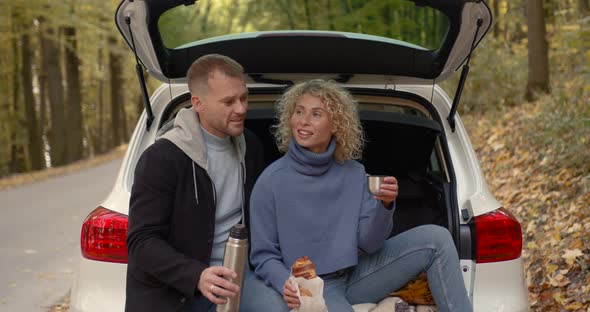 Lovely Couple Sitting in the Trunk of a White Car