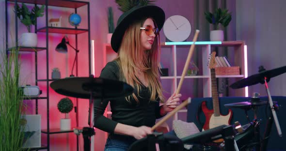 Woman in Sunglasses and Black Hat which throw Up Drumsticks Before Starting to Play on Drums