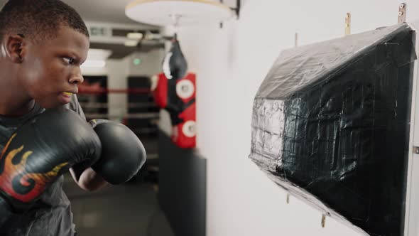 Young Focused African Man Boxer Practicing Punches While Training in Fight Club