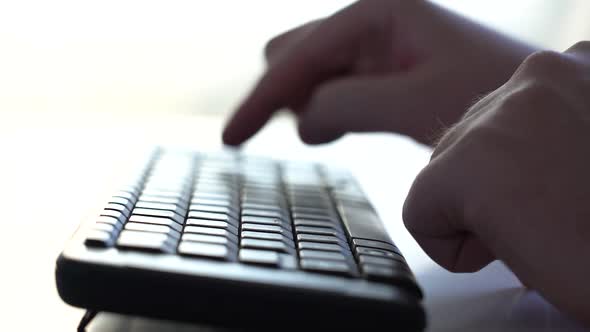 A Man Starts Typing on a Computer Keyboard