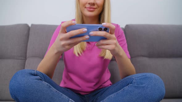 Excited young adult girl playing video game on modern mobile phone gadget in 4k video