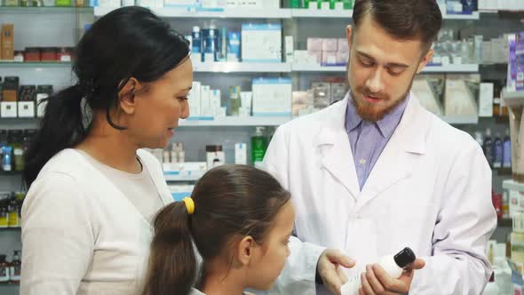 A Young Pharmacist Talks About One of the Pharmacy Products To His Customers
