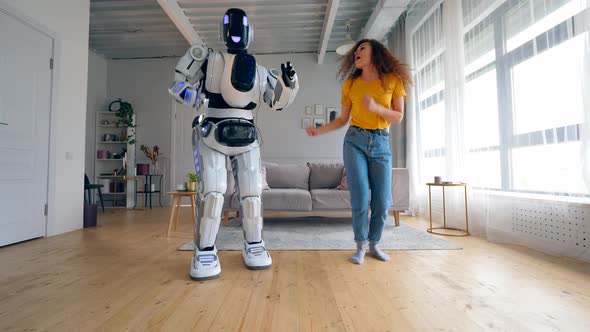 White Droid and Girl Dancing Together. Robot and Human Cooperation.