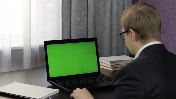 Man Have Video Call Conference on Laptop with Green Screen. Distance Work Online
