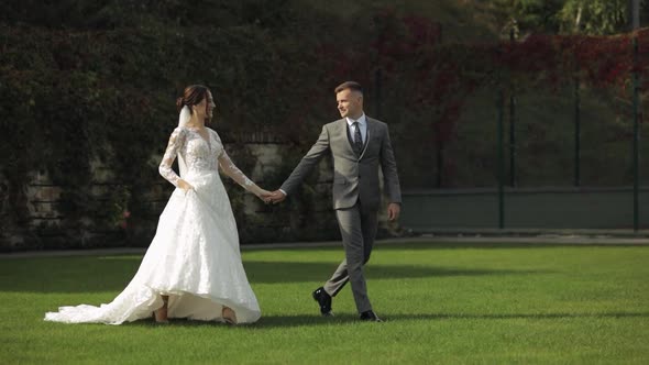 Lovely Newlyweds Caucasian Bride Groom Walking in Park Holding Hands Wedding Couple Family