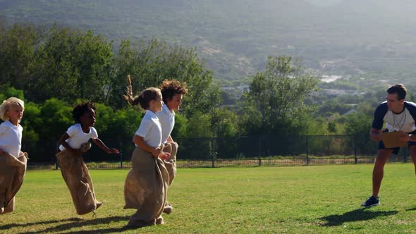 Children playing a sack race in park