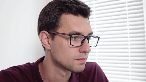 Closeup View of Concentrated Young Businessman in Glasses Working at the Office