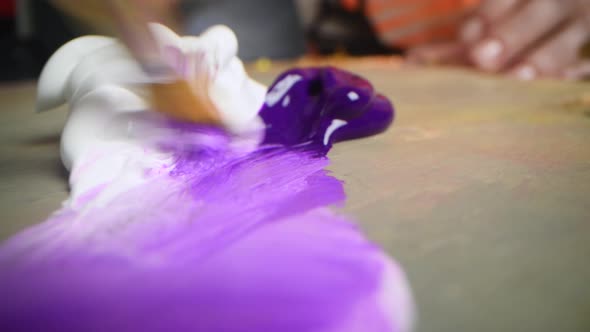 Closeup Shot of Artist Holding Paint Brush and Mix Color on Wooden Palette