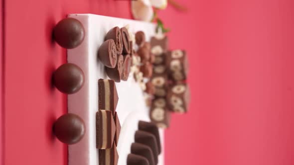 Vertical video, Close up: Composition of chocolate and candies on a red background