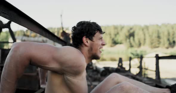 Strong Young Man Is Doing Triceps Dips on Parallel Bars. Exercising Outdoors in the Morning in