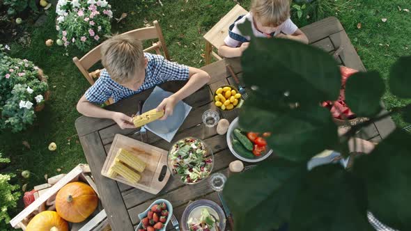Vegan Family Eating Fruit and Vegetables in Garden