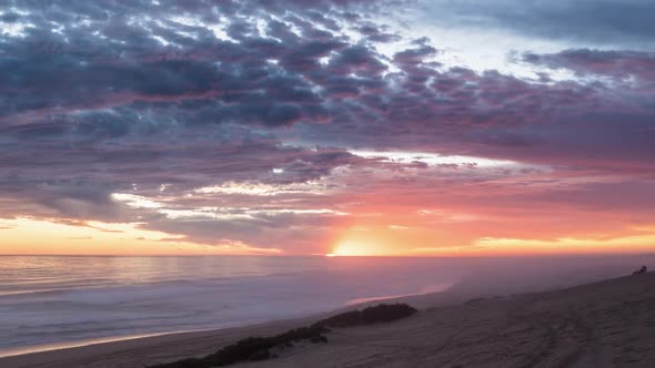 Colorful Sunset with Bloody Sky and Red Clouds over Ocean Beach